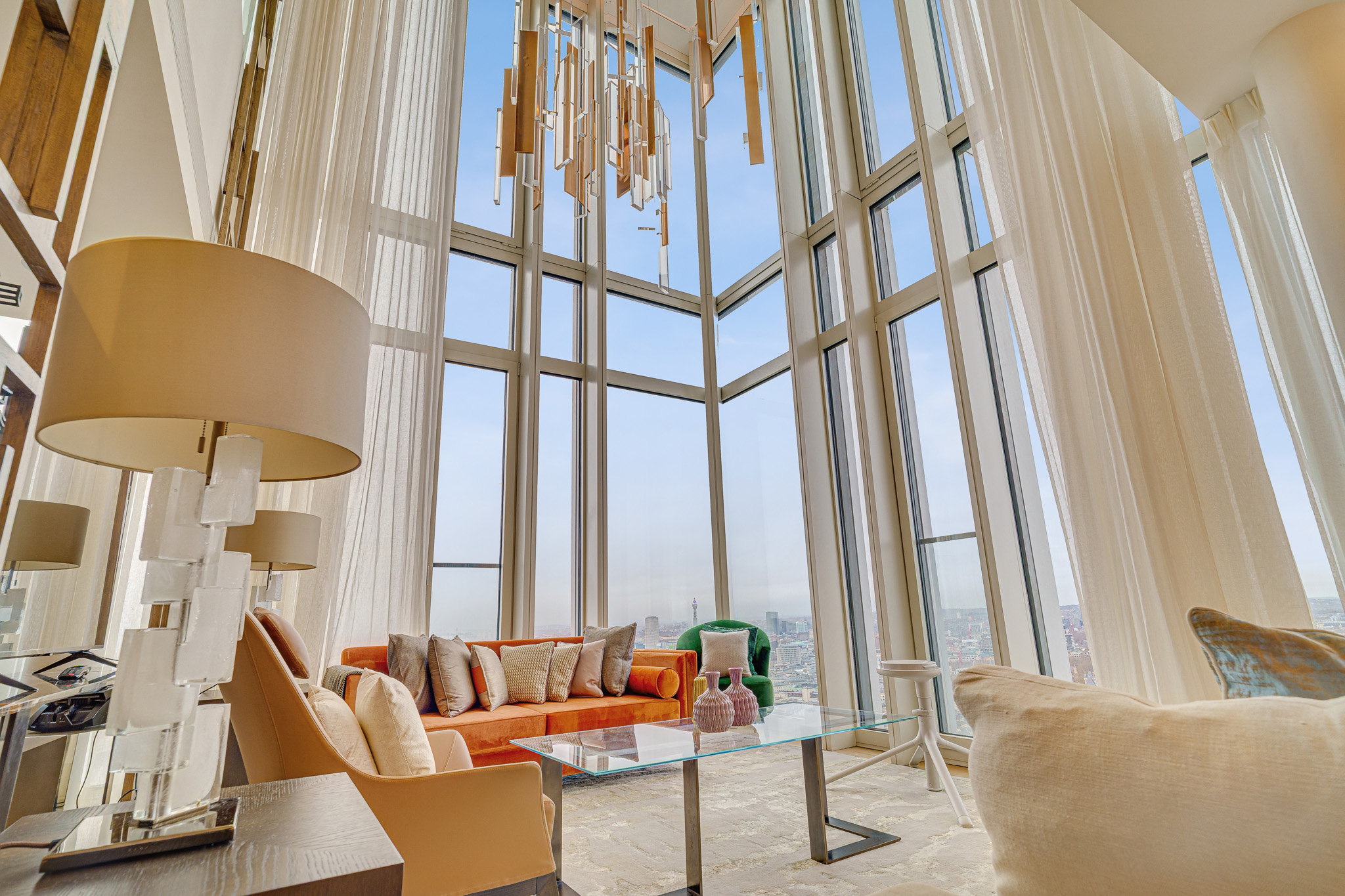 double-height-living-room-property-photography-london Luxury double-height living room with floor-to-ceiling windows, designer interiors and panoramic London skyline views, professionally photographed for a premium residential property.