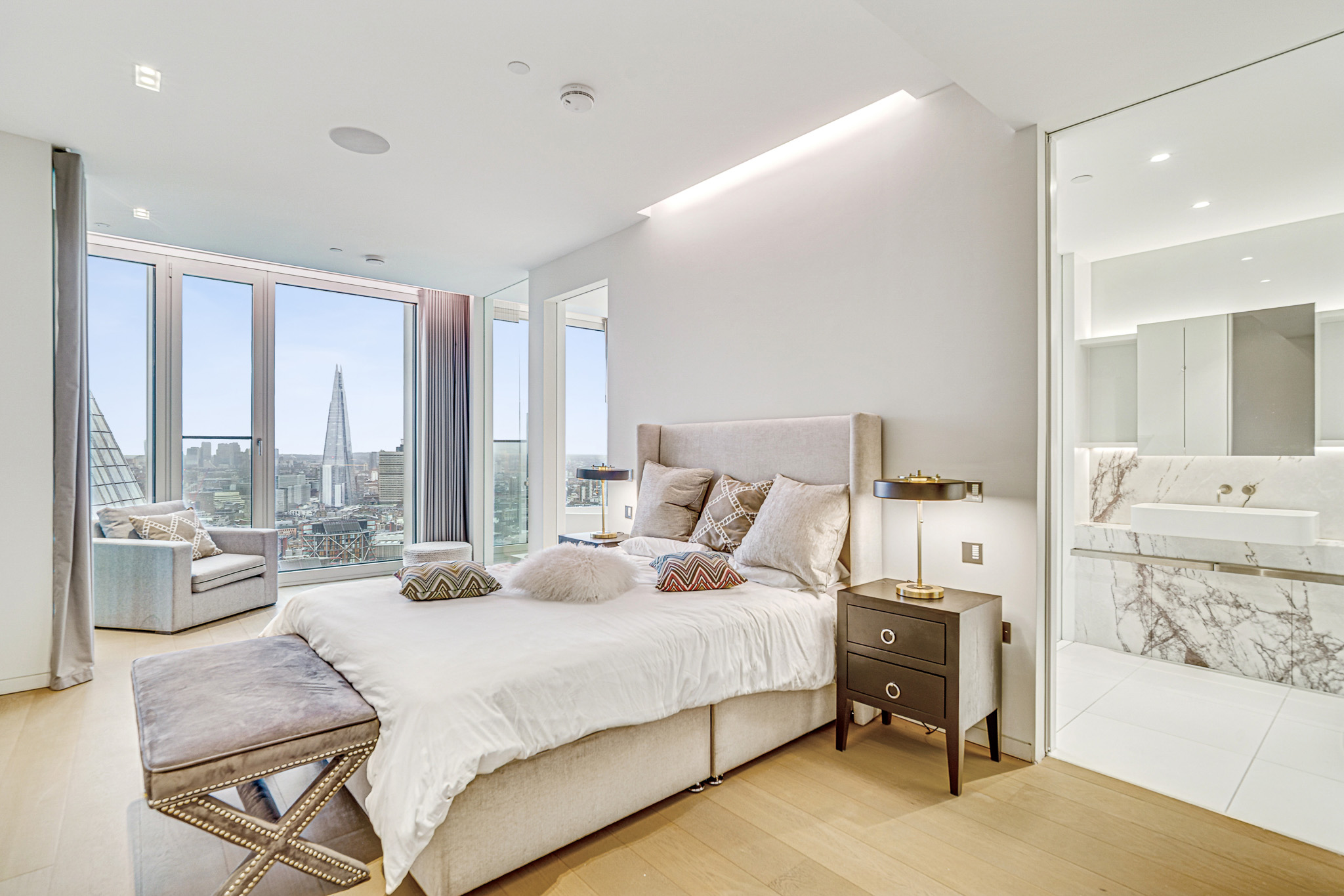 Luxury Bedroom | Property Photography London Luxury bedroom with floor-to-ceiling windows overlooking the London skyline, professionally photographed for a premium residential property.